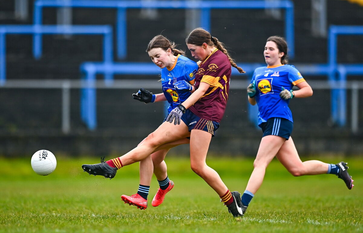 Lauren Woods of Loreto St Michael's scores her side's third goal despite the attention of Eimear Geraghty of Sacred Heart. Pic: Ben McShane/Sportsfile