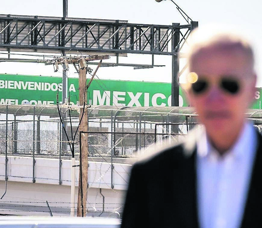 A large 'Welcome to Mexico' sign hung over the Bridge of the Americas is visible as President Joe Biden talks with US Customs and Border Protection officers as he tours the El Paso port of entry in January. Picture: AP Photo/Andrew Harnik