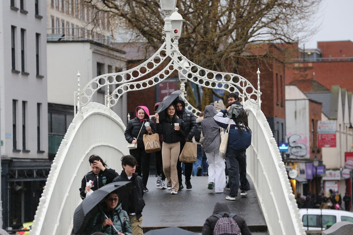 People brave the rainy and windy weather on the Ha'penny Bridge, Bachelors Walk Dublin on Wednesday. Picture: Gareth Chaney/ Collins Photos