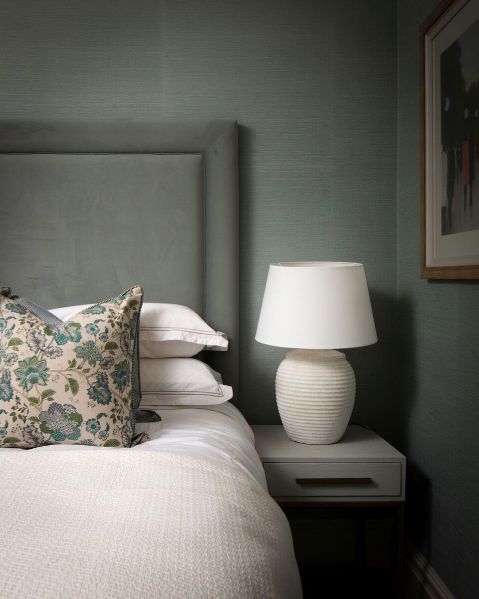  A darker green palette features in the guest bedroom, including a textured wallpaper with a fabric-like quality by Lewis &amp; Wood.