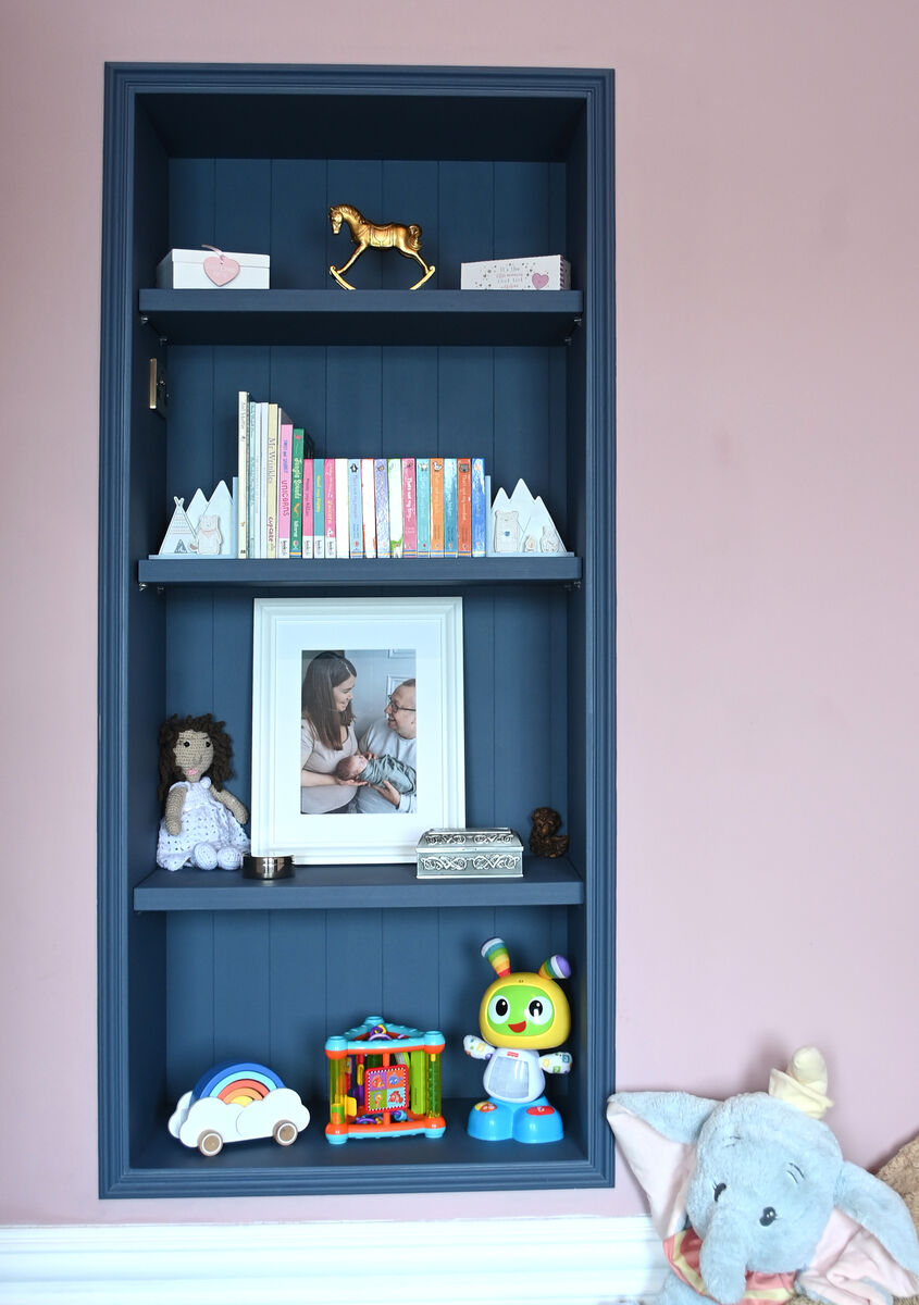 Blue-painted shelving inset in the wall of the child's bedroom. Blue-painted shelving inset in the wall of the child's bedroom.