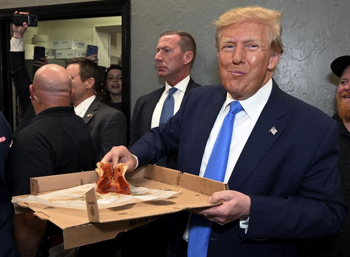 Former President Donald Trump receives his order at Downtown House of Pizza after speaking at the Lee County Republican dinner in Fort Myers, Florida.