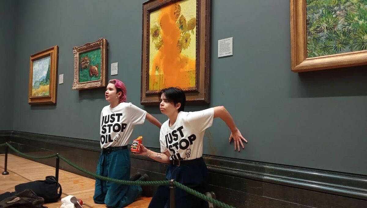 Two Just Stop Oil protesters who have thrown tinned soup at Vincent Van Gogh's famous 1888 work Sunflowers at the National Gallery in London. Picture: Just Stop Oil/PA Wire