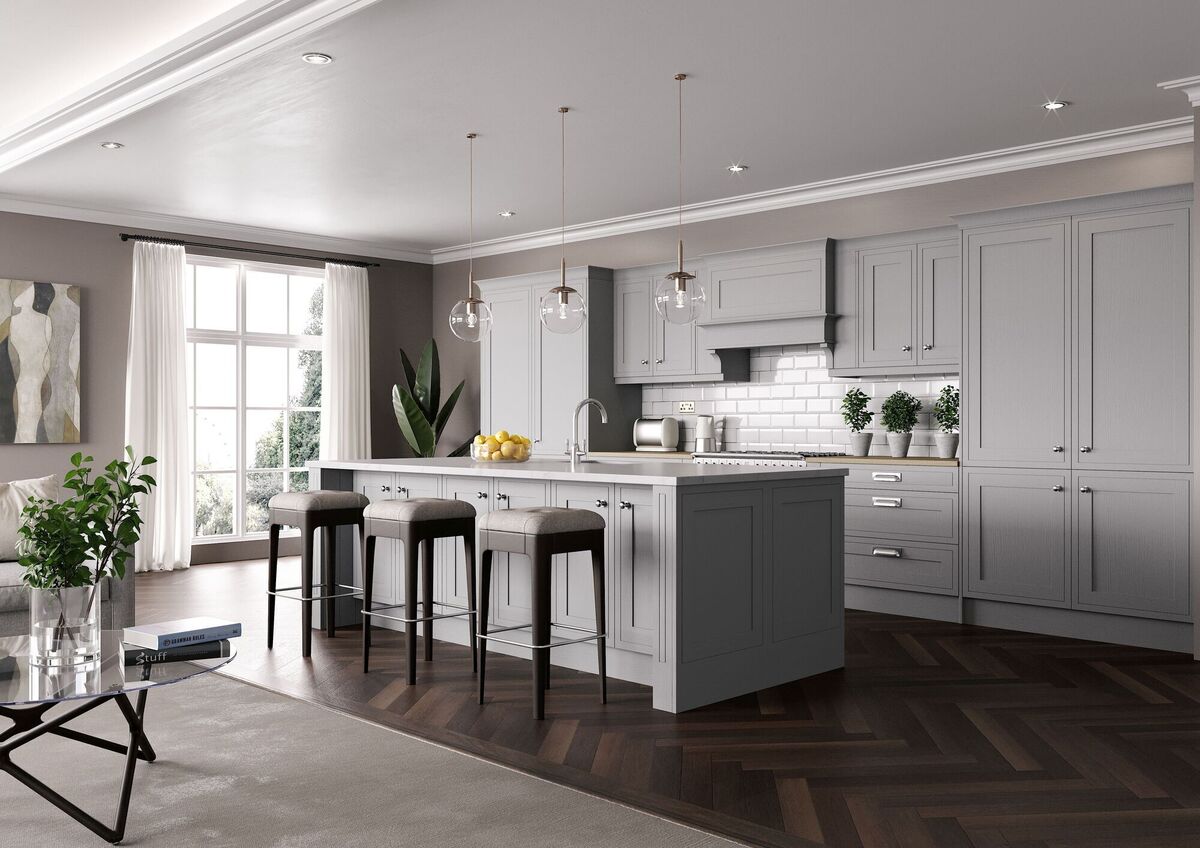  The grey Hampton Oyster cabinets from Cash &amp; Carry Kitchens are styled with sheer curtains for maximum natural light in the space and on-trend chevron-style wooden flooring.