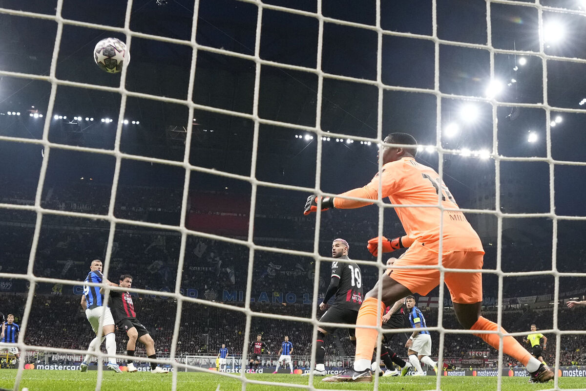 AC Milan's goalkeeper Mike Maignan, right, fails to save the ball as Inter Milan's Edin Dzeko, left, scores his side's opening goal during the Champions League semifinal first leg soccer match between AC Milan and Inter Milan at the San Siro stadium in Milan, Italy, Wednesday, May 10, 2023. (AP Photo/Antonio Calanni)