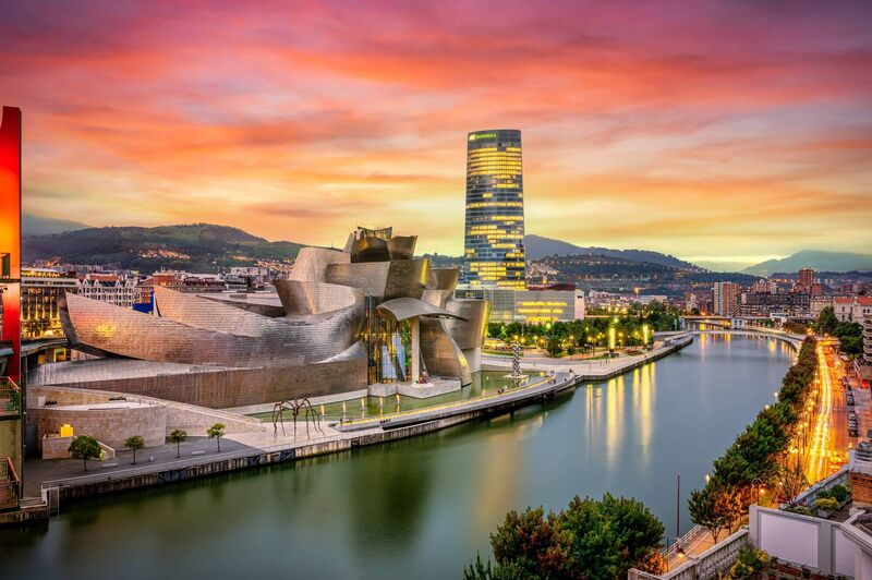 The cityscape of Bilbao at sunset, Spain. The Nervion river crosses Bilbao downtown, hosting in its margins the traditional and modern buildings of the city with Guggenheim museum and Iberdrola tower
