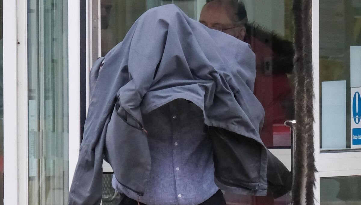 Civilian police worker Timothy Schofield covers his head as he leaves Exeter Crown Court where he is on trial accused of sexual abuse of a teenager. Schofield, 54, is accused of 11 charges of interfering with a child which started when the victim was just a teenager. Picture date: Thursday March 30, 2023.