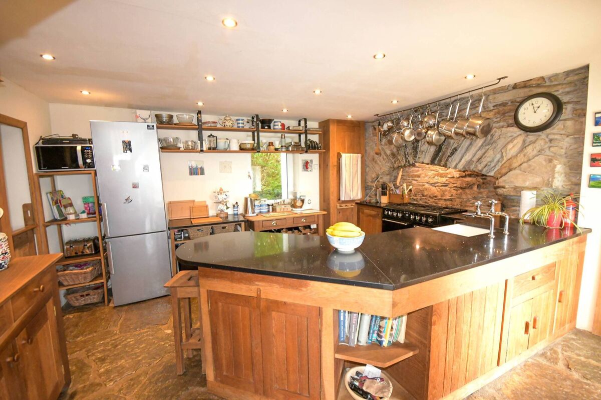 Kitchen with 'discovered' old stone arch which now houses a range cooker. 