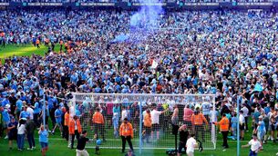 <p>BLUE WAVE: Manchester City fans invade the pitch as they celebrate their Premier League title win. Pic: PA</p>