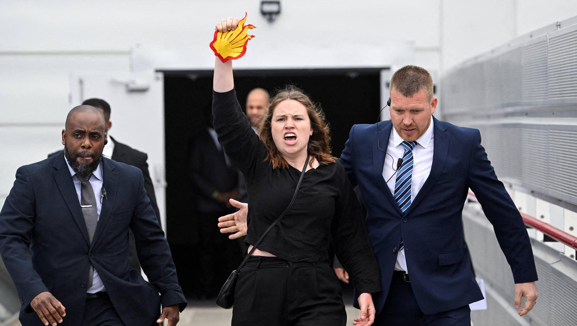 Security personnel remove a protester during the Fossil Free London demonstration outside the venue of Shell's annual shareholder meeting, at the ExCeL center, in London, Britain May 23, 2023. REUTERS/Toby Melville