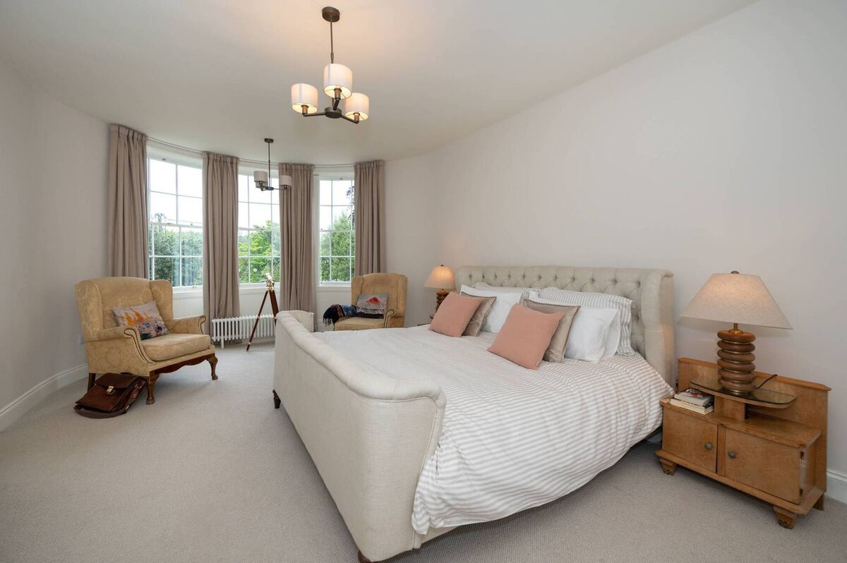 Main bedroom with graceful bow window and water views beyond