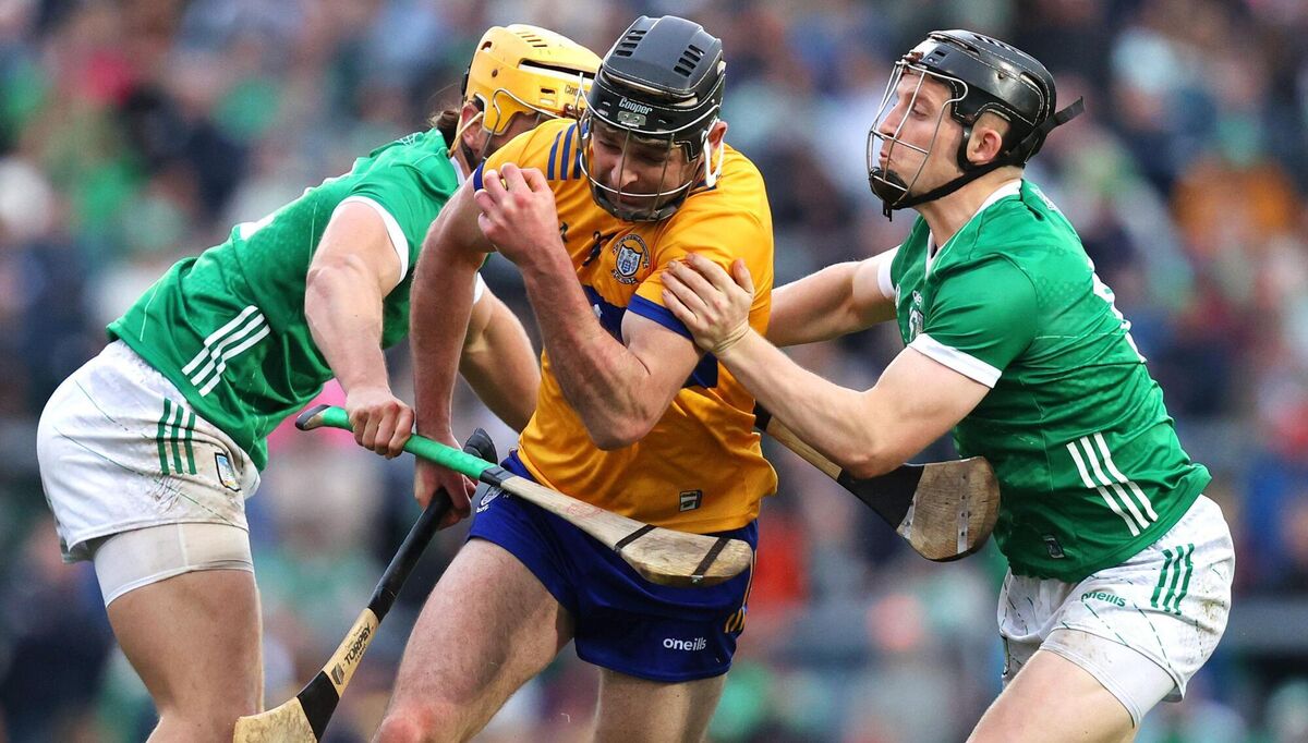 Clare's Cathal Malone is tackled by Tom Morrissey and Peter Casey of Limerick
