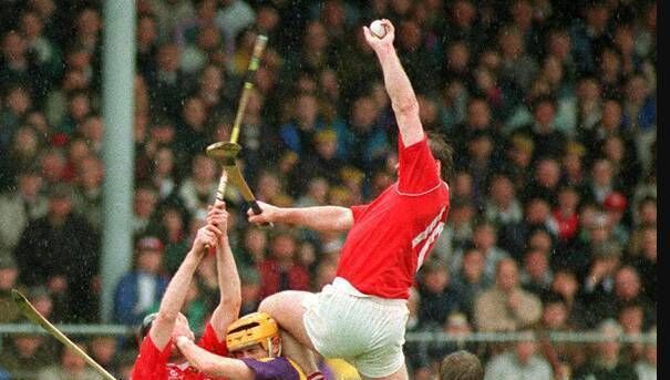 The iconic Teddy McCarthy image from the Irish Examiner archives of the 1993 league final against Wexford when McCarthy’s left knee was ten inches over the head of the Wexford player competing for the same ball