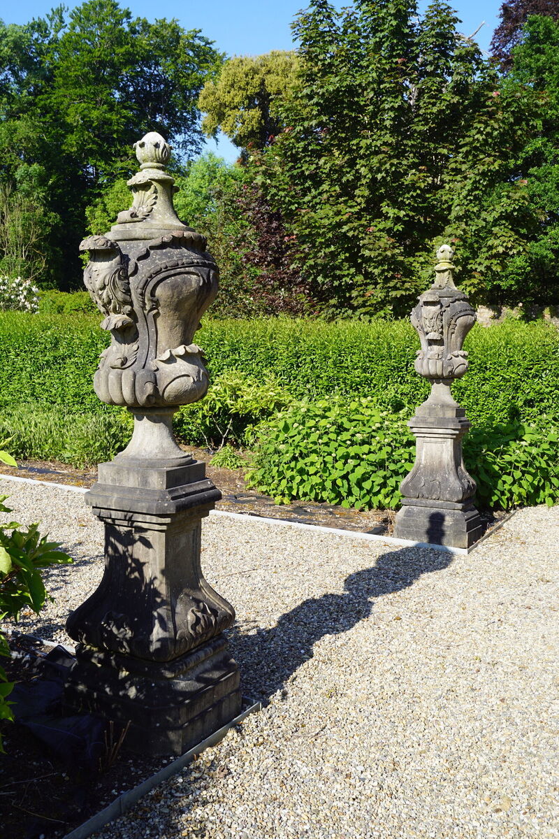 A pair of carved stone French rococo lidded urns and stands at Sheppards.