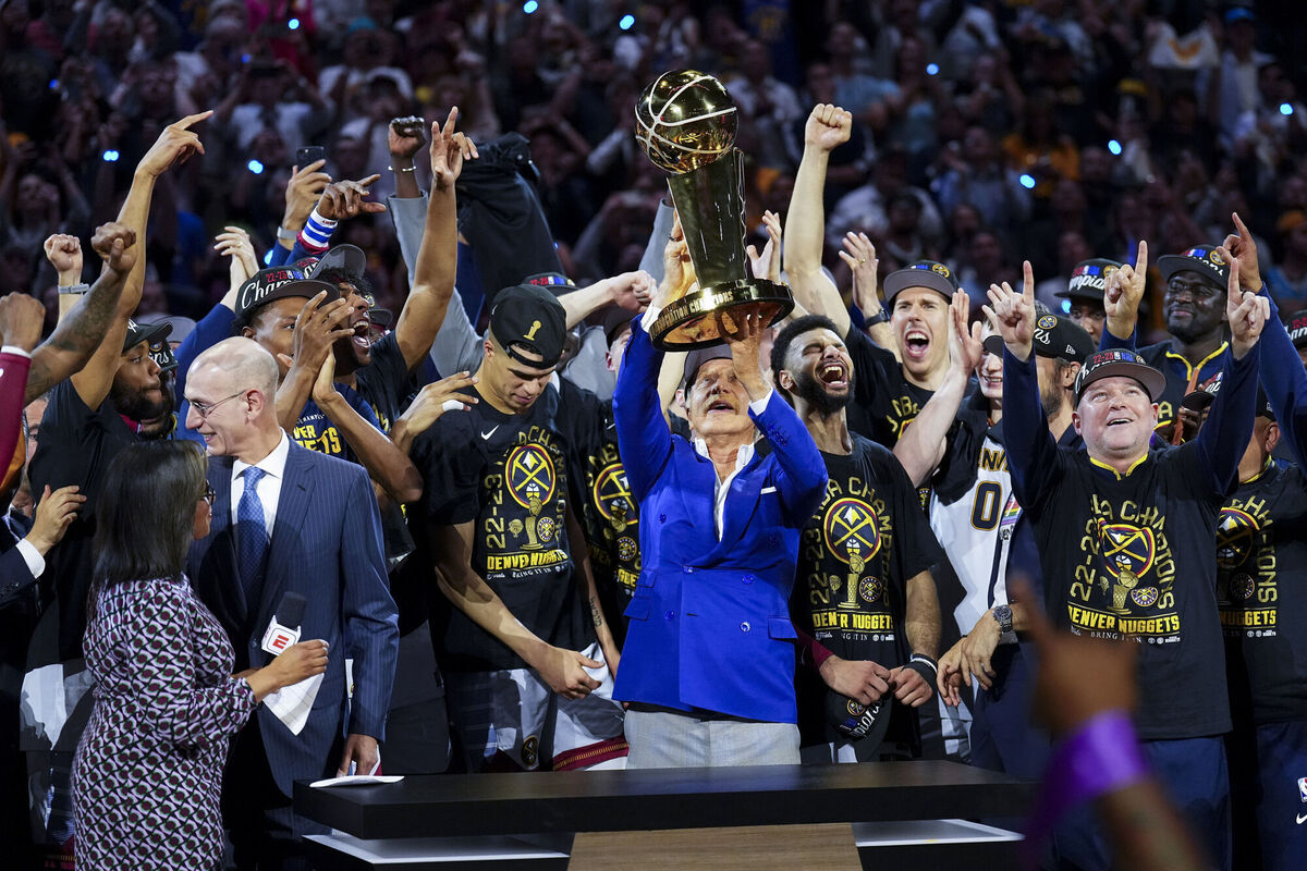 Denver Nuggets owner Stan Kroenke, holds up the Larry O'Brien NBA Championship Trophy