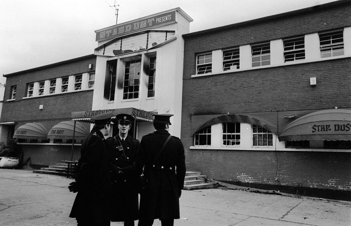 Police stand outside the main entrance of a fire-blackened Stardust Disco in Artane, Dublin, on February 14, 1981. Picture: Tony Harris/PA Wire