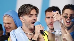 <p>Manchester City's Jack Grealish with a bottle of vodka on stage after they completed the treble. Picture: PA.</p>