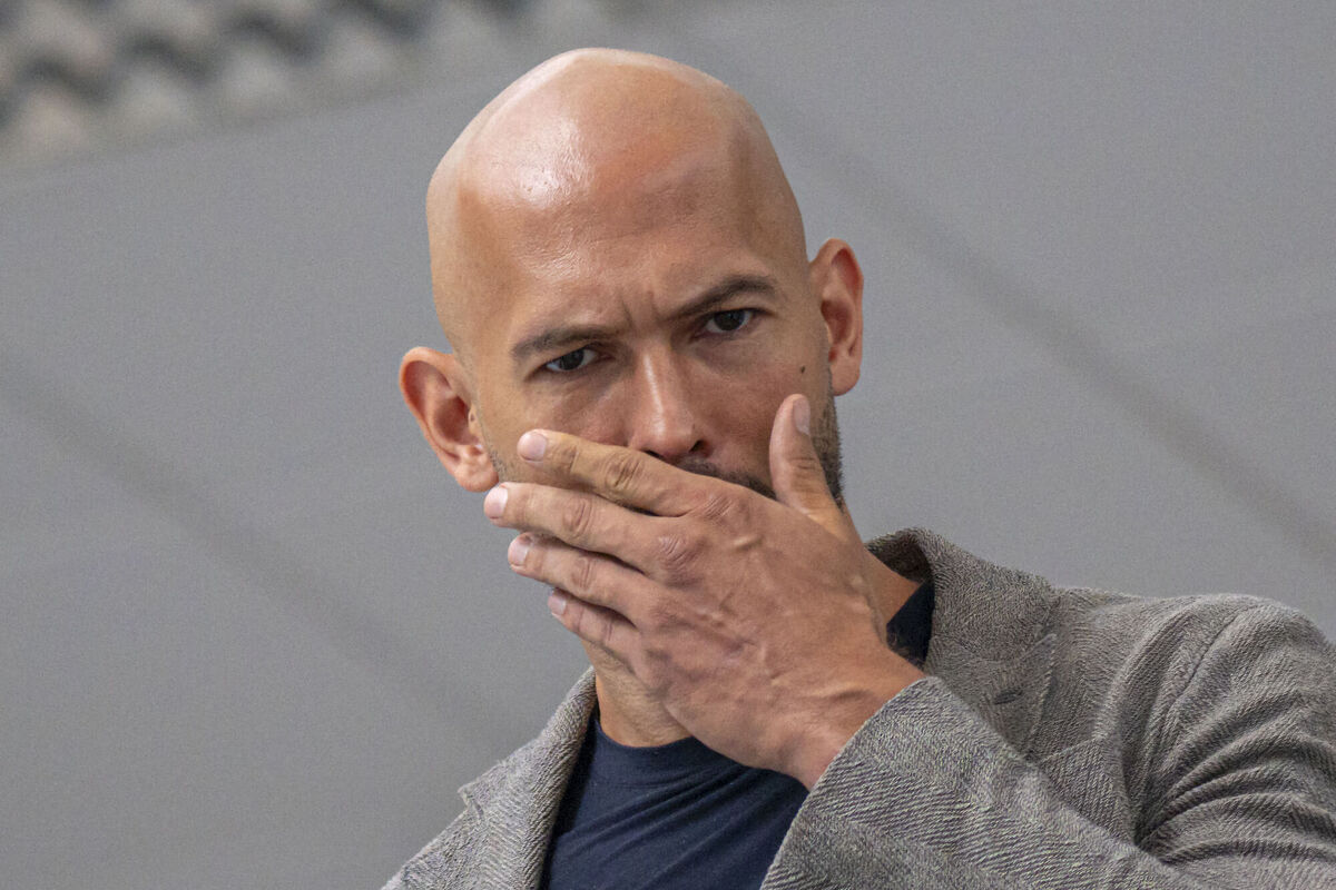 Andrew Tate wipes his face as he leaves the Bucharest Tribunal after the first hearing in their trial, meant to establish if they will remain under house arrest, in Bucharest, Romania. Picture: AP Photo/Vadim Ghirda