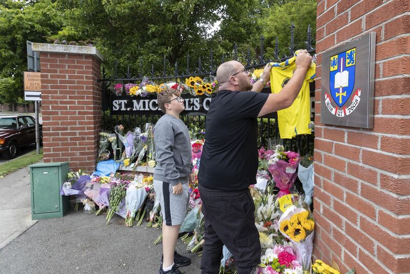 The coach of Belmont FC adds a Belmont jersey to floral tributes at the entrance to St Michael's College. Picture: Colin Keegan, Collins Dublin