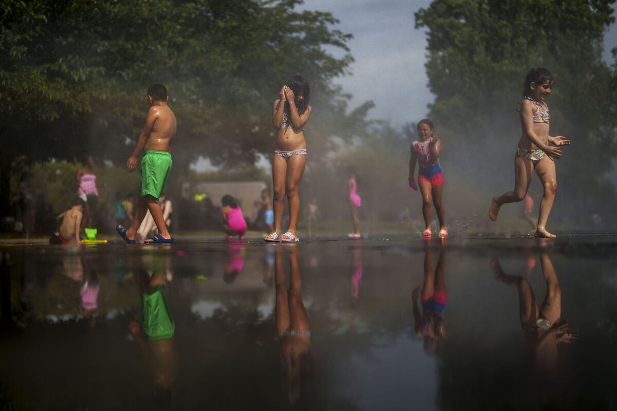Children cool off at an urban beach in Madrid, Spain.