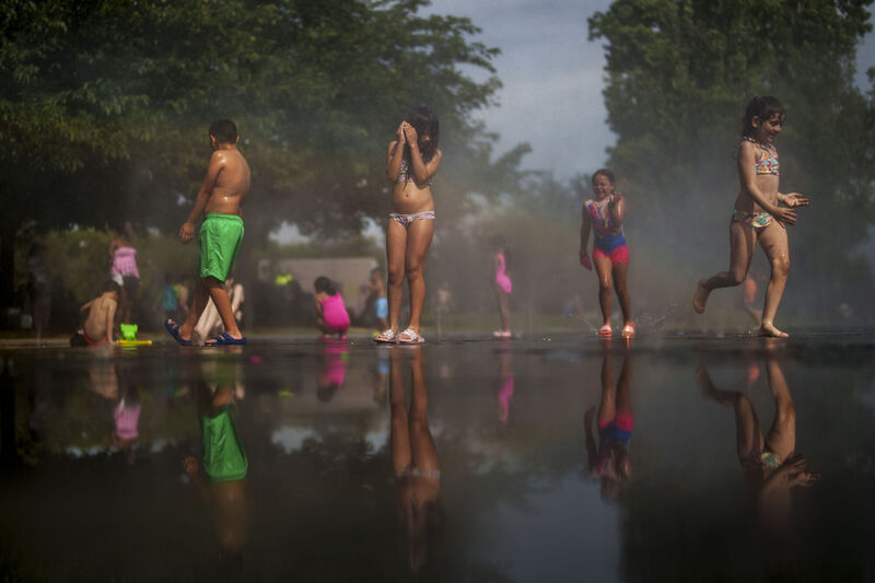 Children cool off at an urban beach in Madrid, Spain.
