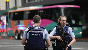 Armed New Zealand police officers stand outside a hotel housing a team from the Fifa Women’s World Cup in the central business district following a shooting in Auckland, New Zealand (Abbie Parr/AP/PA)