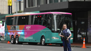 Armed New Zealand police officers stand outside a hotel housing a team from the Women’s World Cup in the central business district following a shooting in Auckland (Abbie Parr/AP)