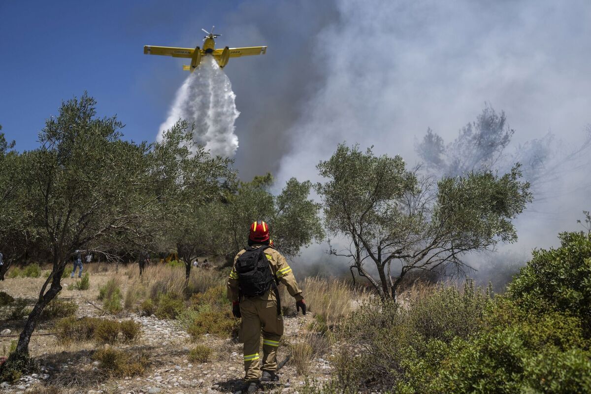 An aircraft drops water over a wildfire in Vati village, on the Aegean Sea island of Rhodes. Picture: AP Photo/Petros Giannakouris An aircraft drops water over a wildfire in Vati village, on the Aegean Sea island of Rhodes. Picture: AP Photo/Petros Giannakouris