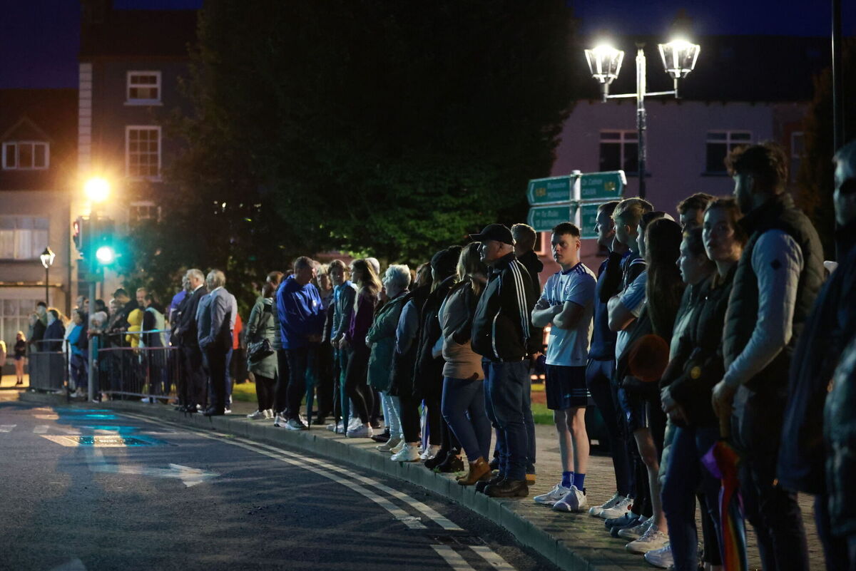 People form a guard of honour as the hearse carrying the remains of Kiea McCann arrives to the family home in Clones, Co  Monaghan. Picture: Liam McBurney/PA Wire