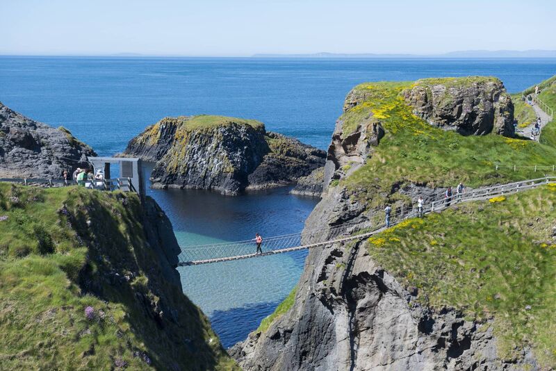 People cross the famous Carrick-A-Rede Rope Bridge in County Antrim, Northern Ireland