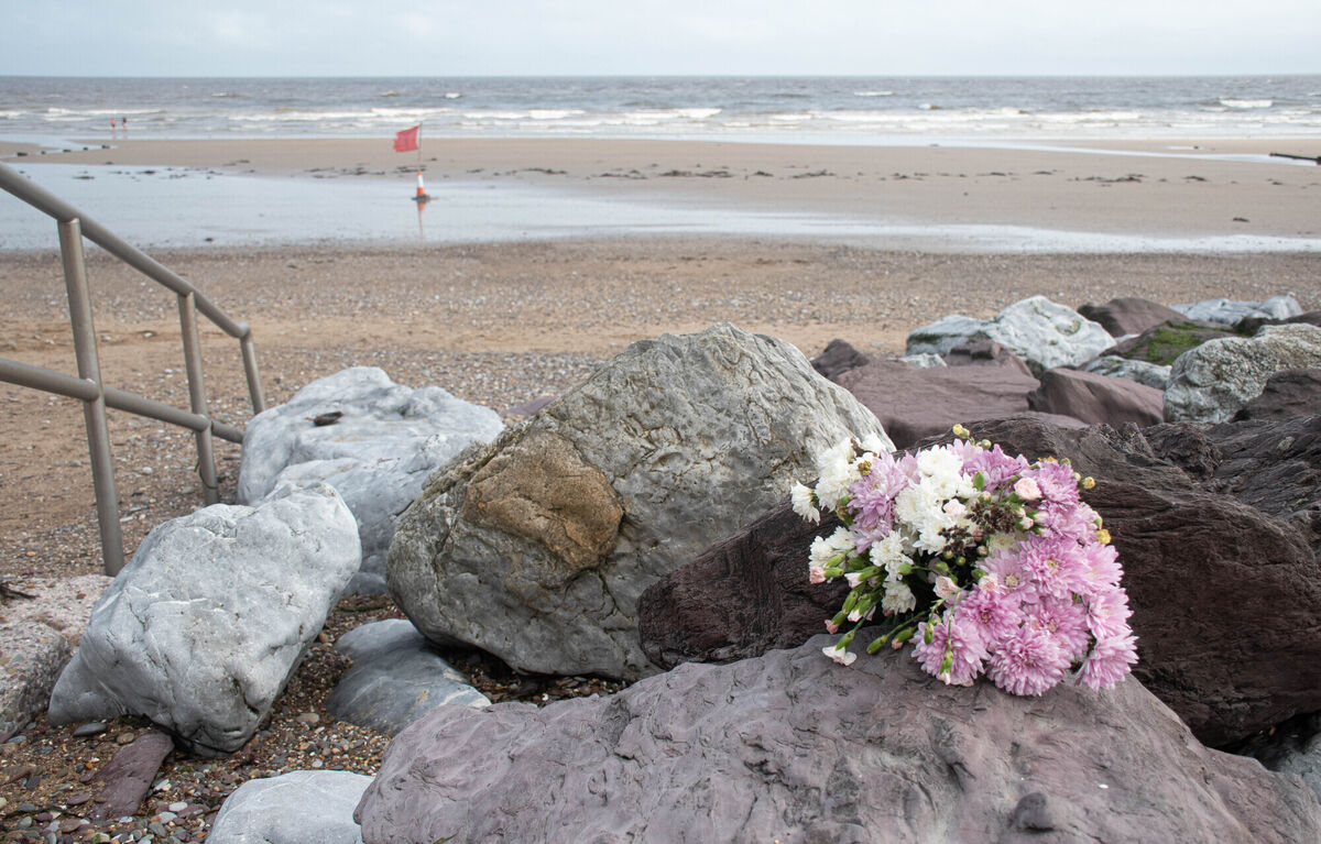Flowers left at the spot where the swimmers entered the water. Picture: Howard Crowdy
