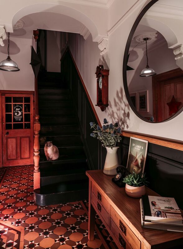  Brian and Peter's home has original floor tiling in the hall with a modern mirror and console table showing the balance between antique and modern.