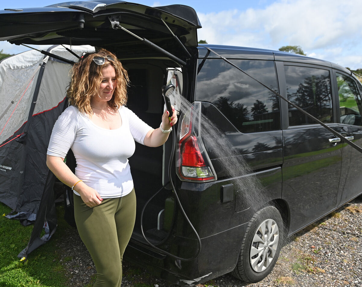 Jennifer showing off the shower in her micro-camper. 