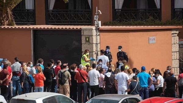 A psychologist talks to a group of workers outside the H10 Costa Adeje Palace Hotel in La Caleta, yesterday, where hundreds of people were confined after an Italian tourist was hospitalised with a case of coronavirus. Tourists staying in the four-star hotel on the Spanish island of Tenerife, in the Canary archipelago, were confined to their rooms. Pictures: Desiree Martin / AFP/Gregorio Borgia