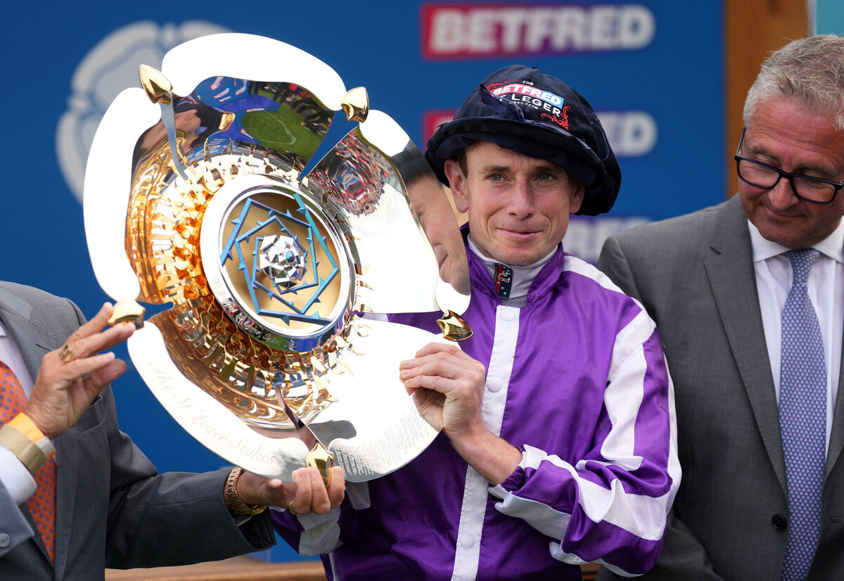Ryan Moore celebrates with the trophy after winning the Betfred St Leger Stakes on Continuous.