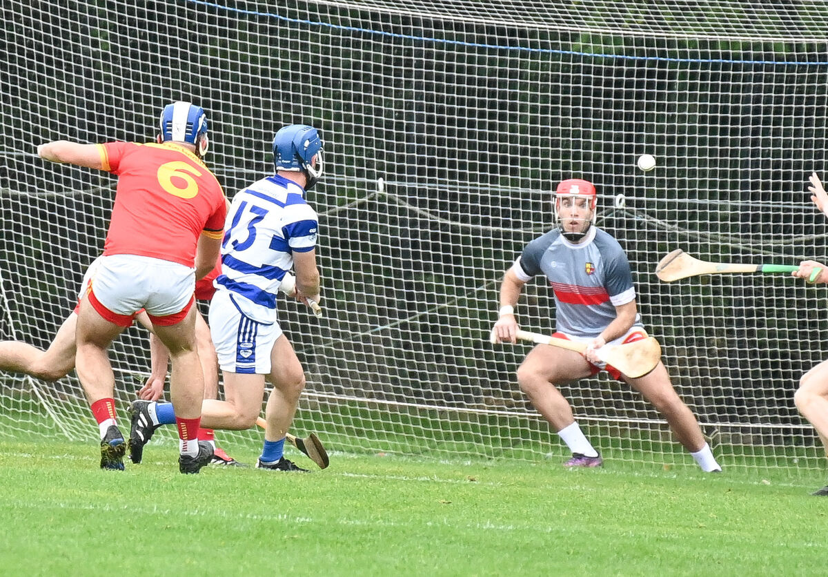  Inniscarra's David O'Keeffe hammers the ball to the Mallow net past Padge Buckley, during their Senior AHC clash, at Blarney.