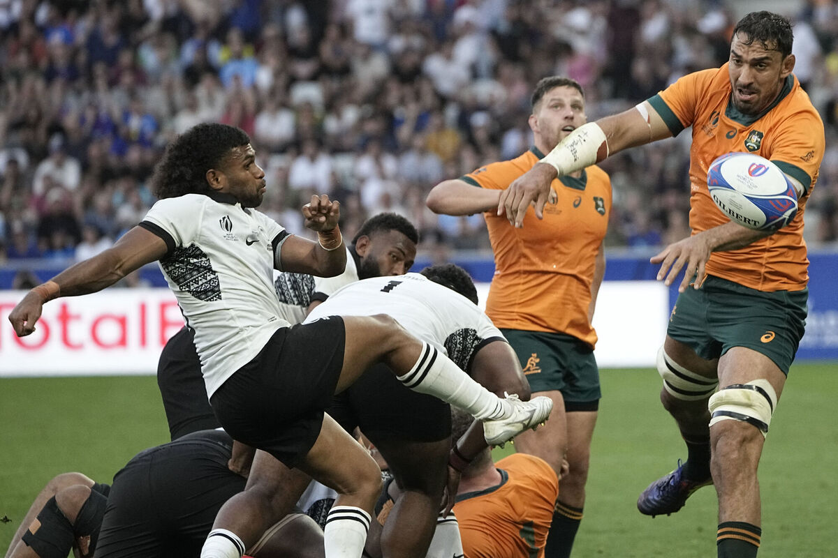 Fiji's Simione Kuruvoli kicks the ball as it passes by Australia's Will Skelton. Fiji's Simione Kuruvoli kicks the ball as it passes by Australia's Will Skelton.