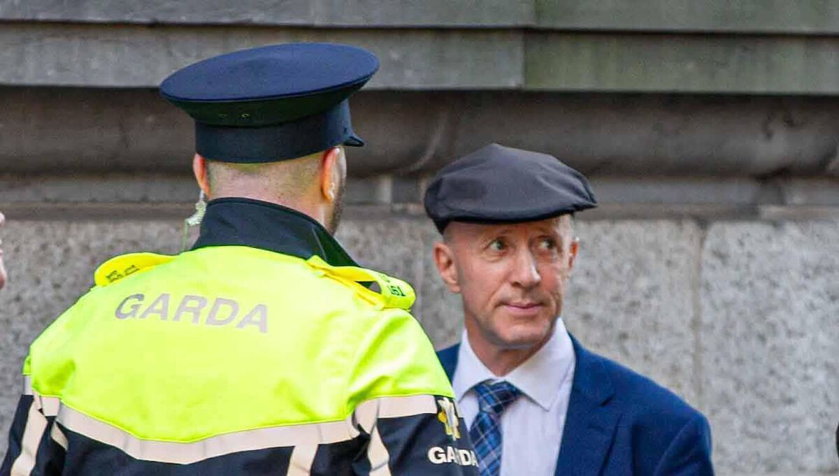 Michael Healy-Rae with gardaí moments after being confronted by protesters near Leinster House on the first day of the Dáil