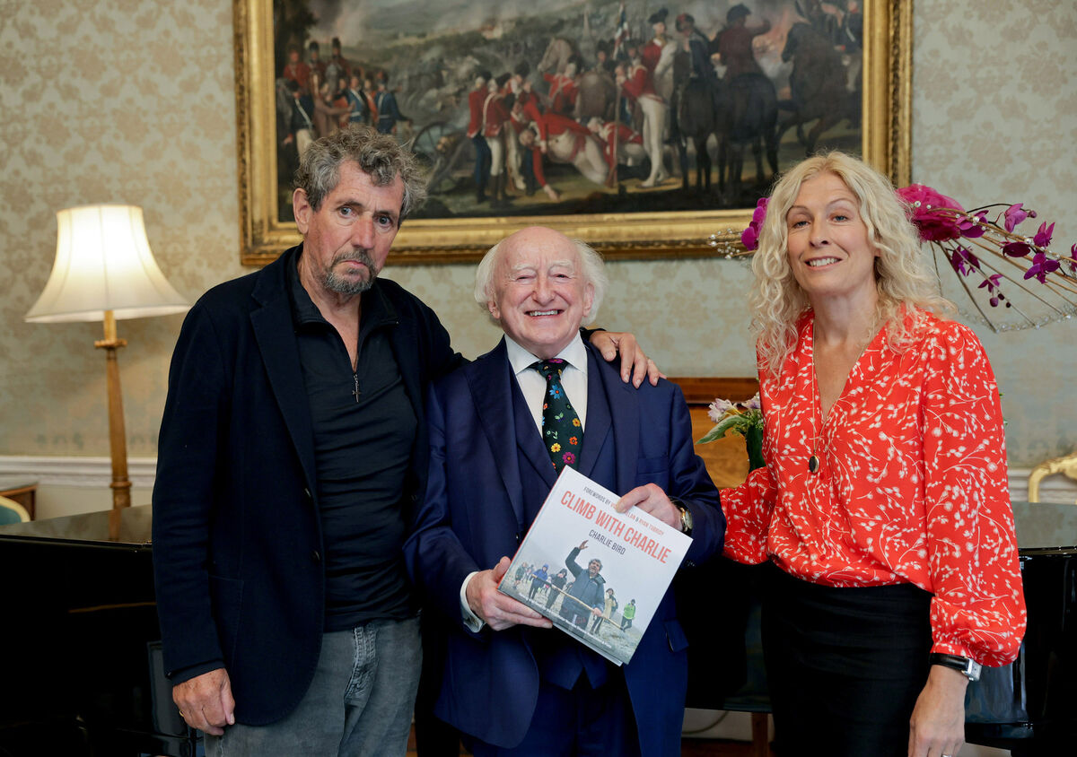 President Michael D Higgins with Charlie Bird and his wife Claire Mould with a copy of his book ‘Climb with Charlie’ at Áras an Uachtaráin. File picture: Maxwells