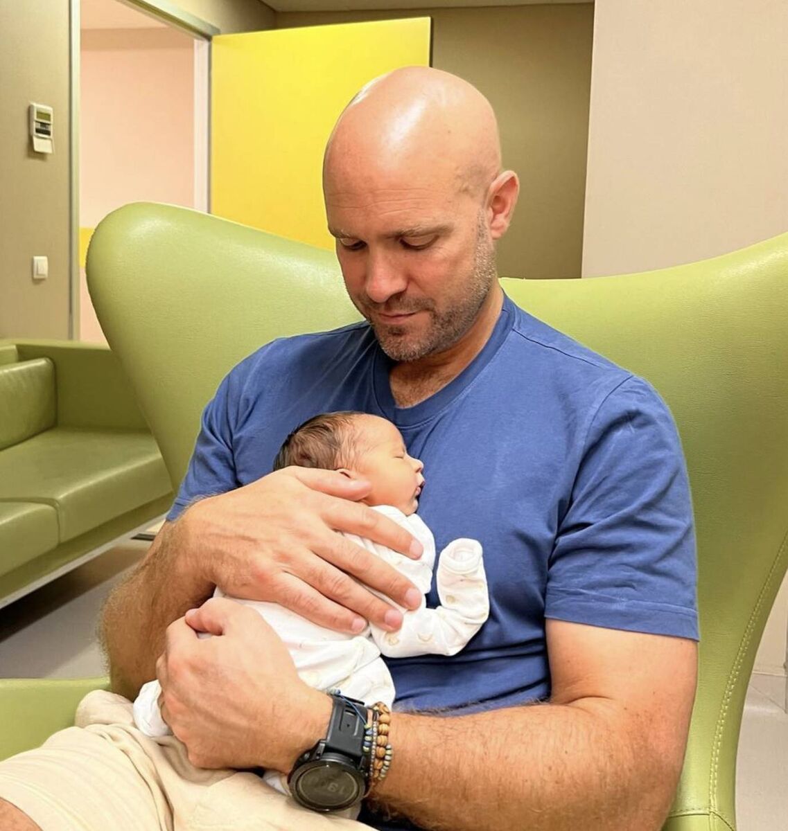 New dad Jamie Crawford cradles his newborn daughter 
