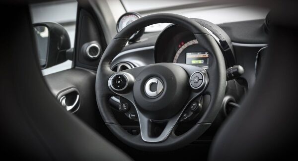 The practical interior of the Smart ForFour Electric Drive, which is designed for short journeys, with people hopping in and out.