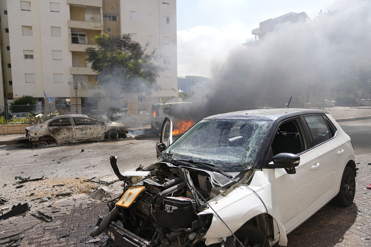 Cars are on fire after they were hit by rockets from the Gaza Strip in Ashkelon, Israel, on Saturday (Picture: AP /Tsafrir Abayov)
