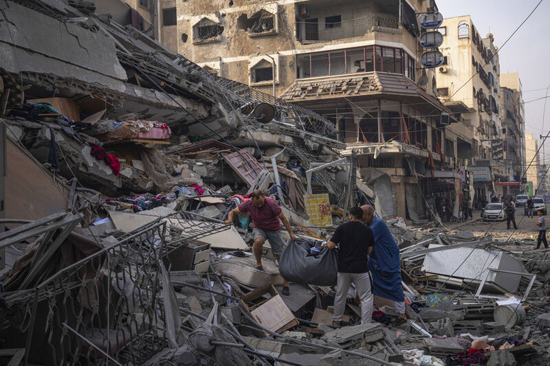 Palestinians scour the debris from the rubble of a building after it was struck by an Israeli airstrike, in Gaza City on Sunday. Picture: AP Photo/Fatima Shbair