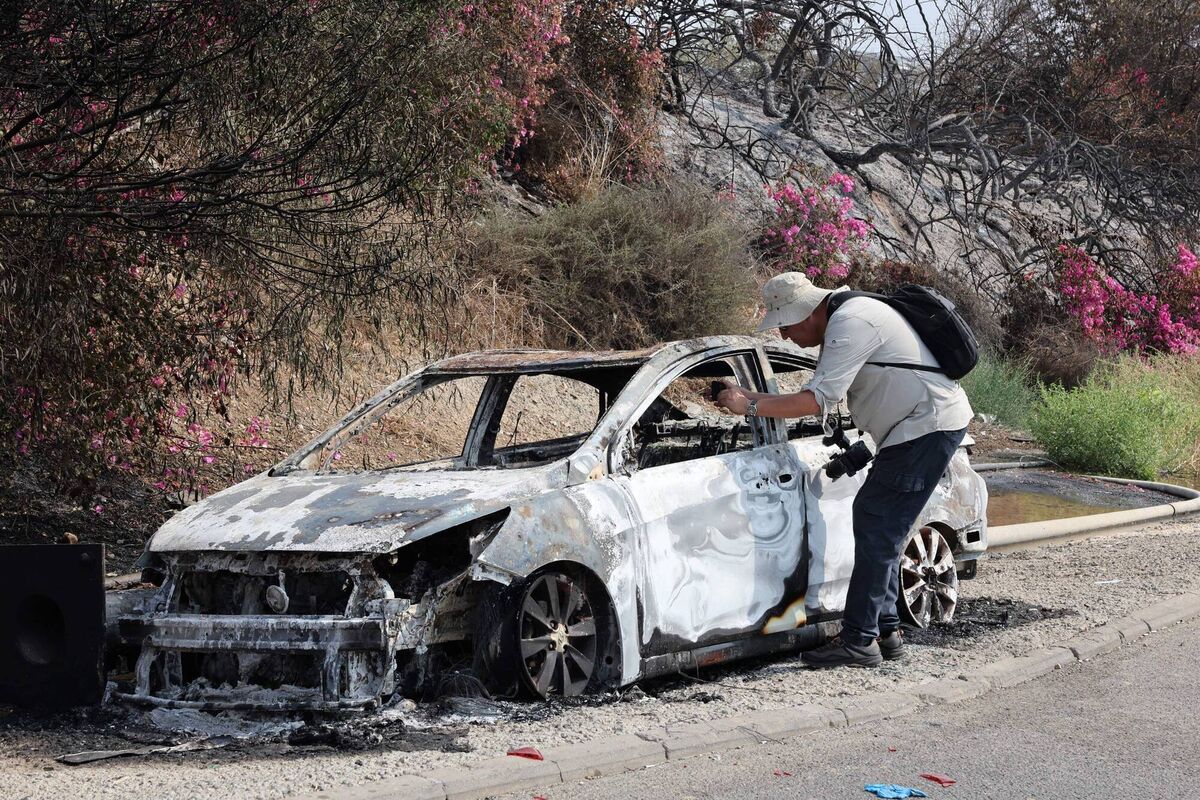 A man takes pictures of a car burned during an infiltration by Palestinian militants from the Gaza Strip, a day after the attack near the southern city of Sderot on October 8, 2023. (Photo by JACK GUEZ/AFP via Getty Images) A man takes pictures of a car burned during an infiltration by Palestinian militants from the Gaza Strip, a day after the attack near the southern city of Sderot on October 8, 2023. (Photo by JACK GUEZ/AFP via Getty Images)