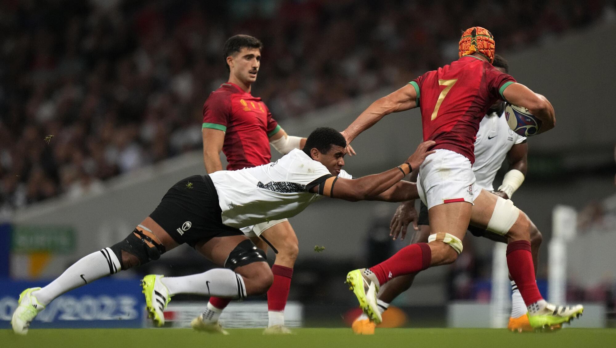 Fiji's Temo Mayanavanua, left, challenges Portugal's Nicolas Martins. (AP Photo/Pavel Golovkin)