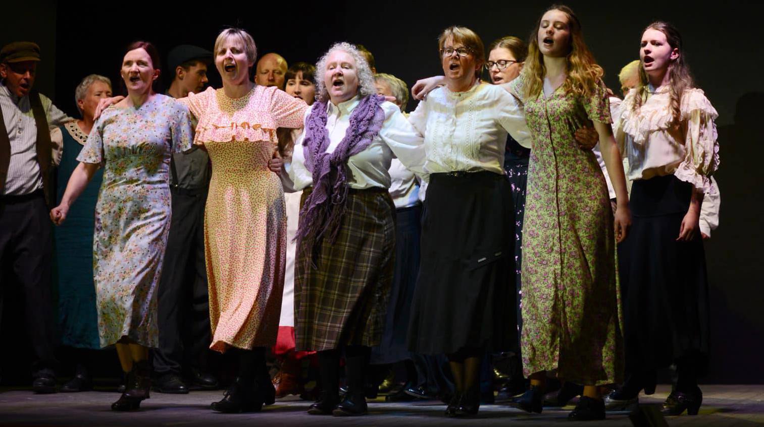 A scene from AnTuairín Dubh, with Nóirín Uí Thuama, centre with purple scarf.