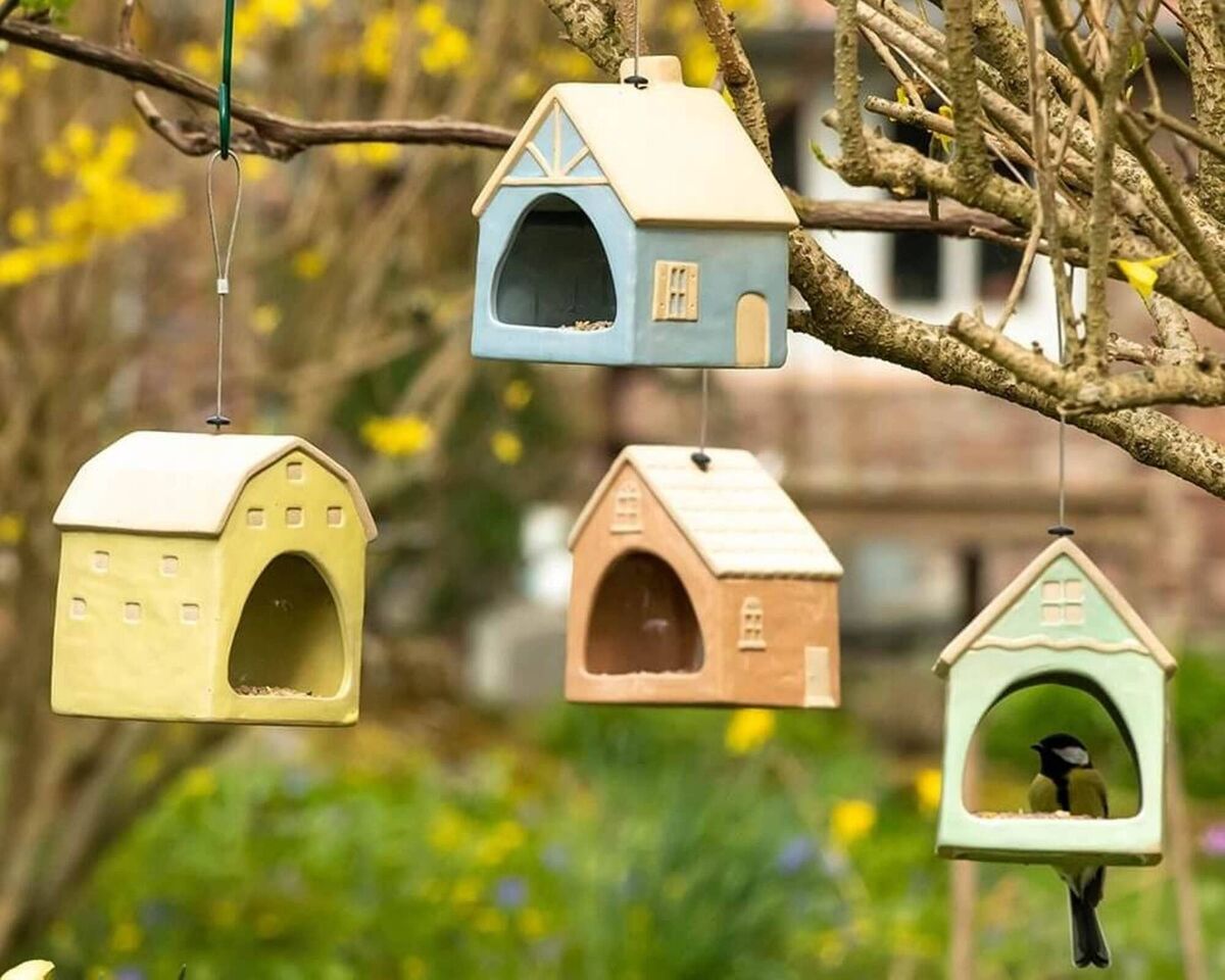 Set up different feeding zones with individual tree or hook hung feeders like these whimsical, ceramic bird feeding houses by Suvila, 11.95 each, vivara.ie.