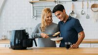 Couple preparing meal in air fryer