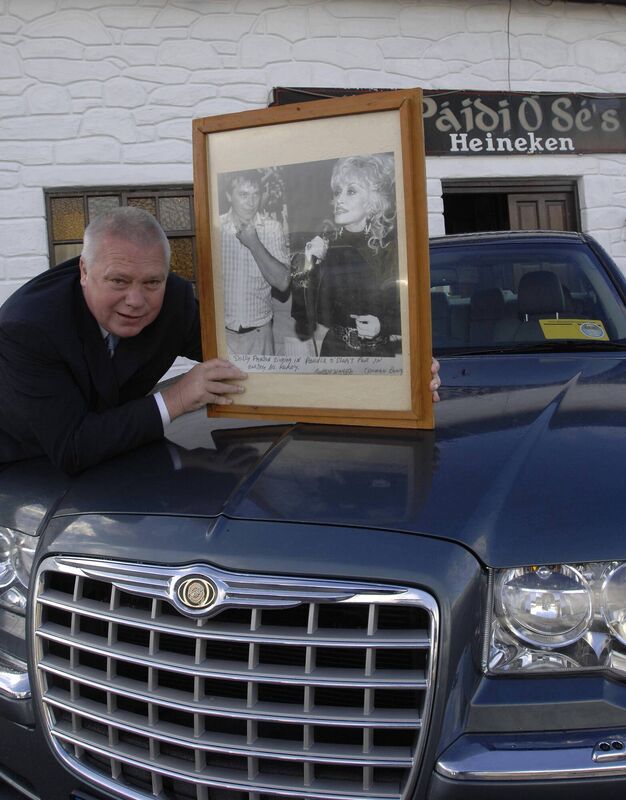 Páidí Ó Sé with a framed photo of himself and Dolly Parton from 1990. Picture: Don MacMonagle