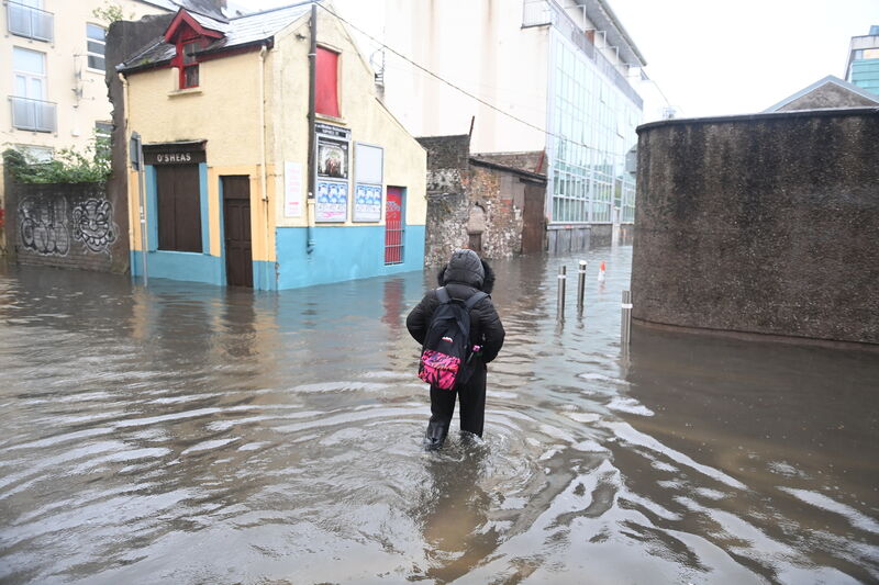 People walk through flood waters at Rutland Street in Cork. Picture: Larry Cummins 